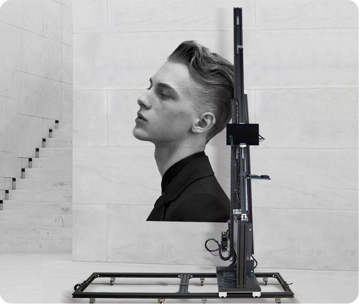 Wheel-type wall printer next to a large black-and-white portrait printed on a stone-look wall