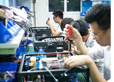 Technicians assembling laser power supply electronics